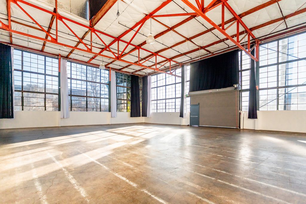 Studio 5 has orange industrial beams on the ceiling and tons of windows that let in natural light. It is also a large multiple set studio rental Berkeley has to offer with 3,700 square feet of space. There are also blackout curtains on the walls and a private loading dock.