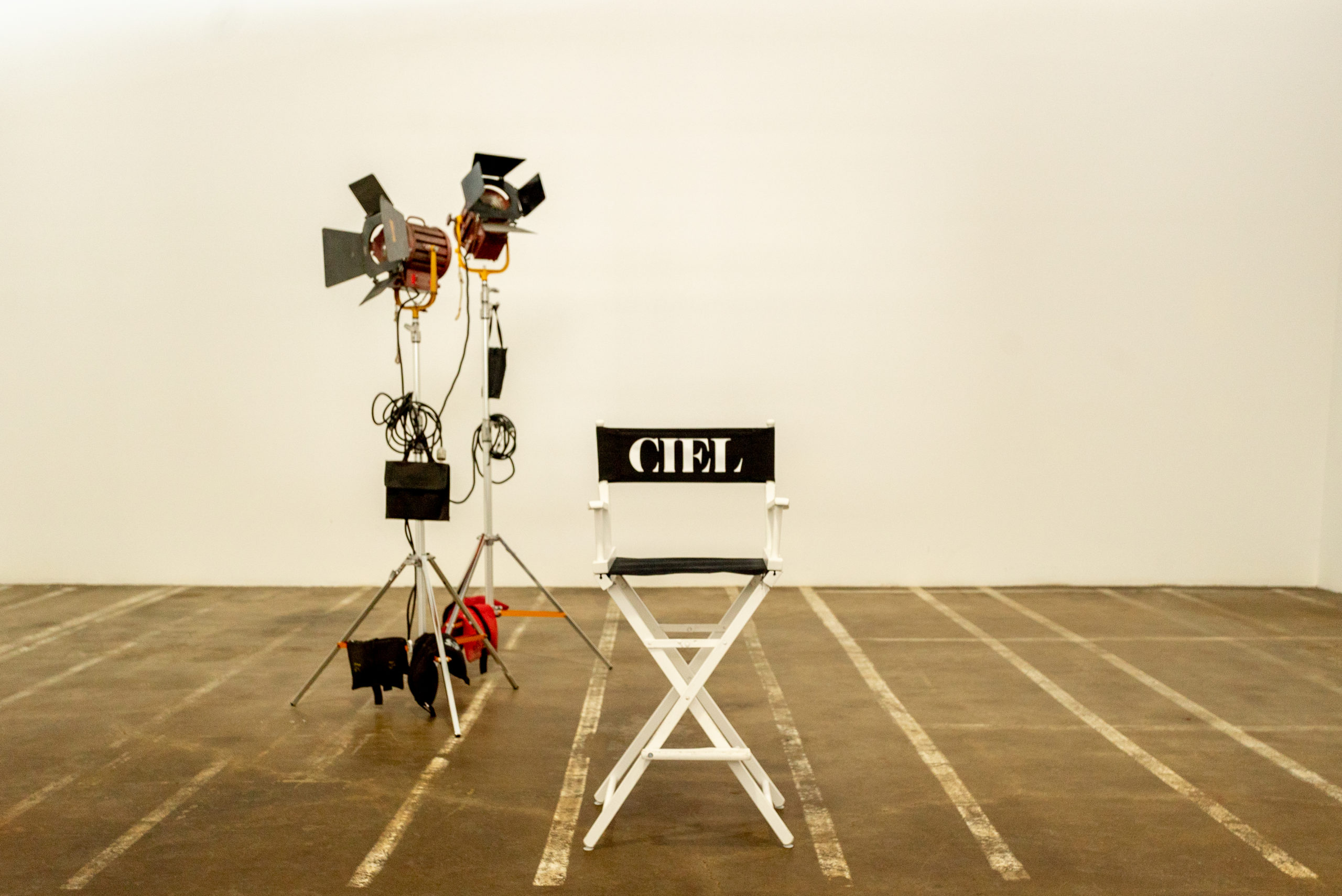 A close up view of two production lights and a black director's chair that says 