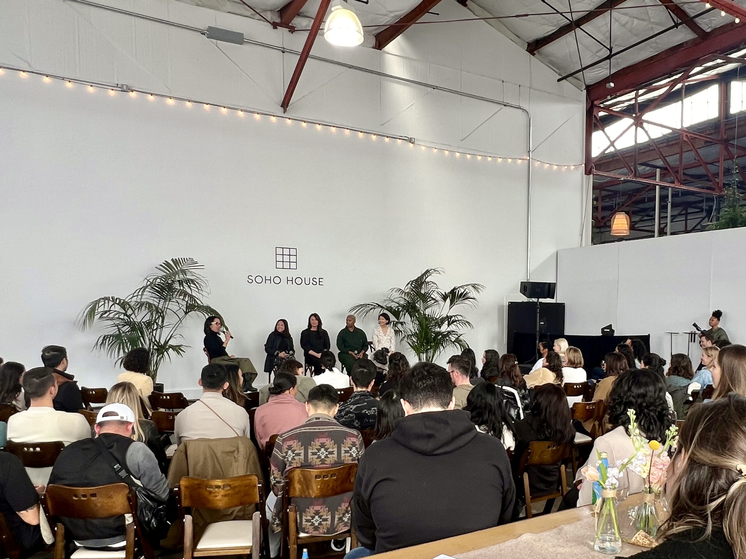 A panel of people are speaking at a creative space in Berkeley. The room has high ceilings and white walls.